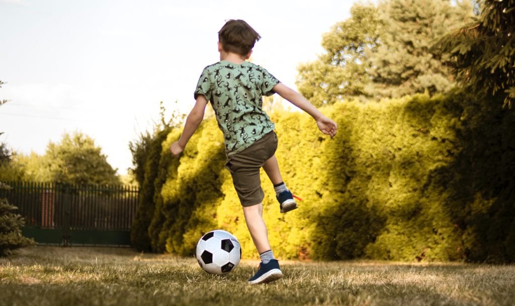 Photo of a boy playing soccer outside