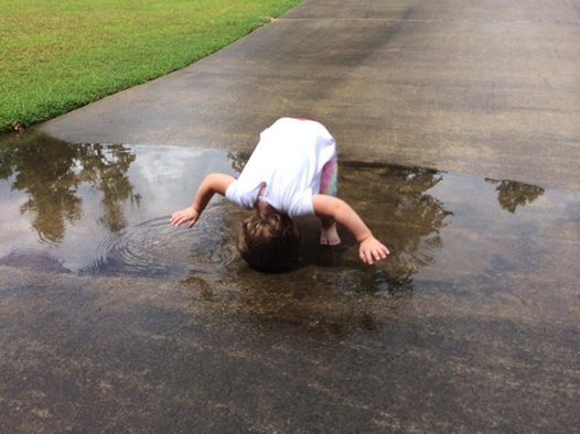 Picture of my daughter "washing her hair" in a puddle, demonstrating creativity of kids. 