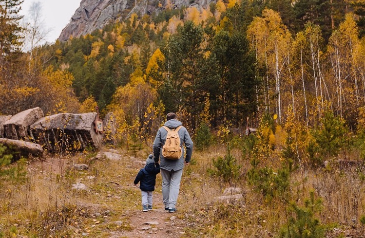 Picture of a man hiking with a little boy. Getting out into nature is a good practice of mindfulness.