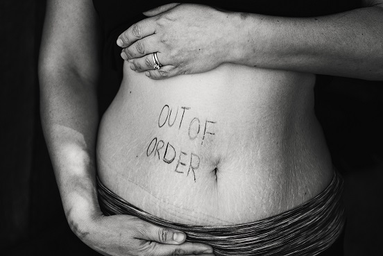 Picture of a woman's belly with the words "Out of Order".