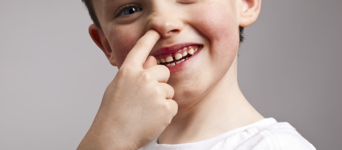 Portrait of little boy picking his nose