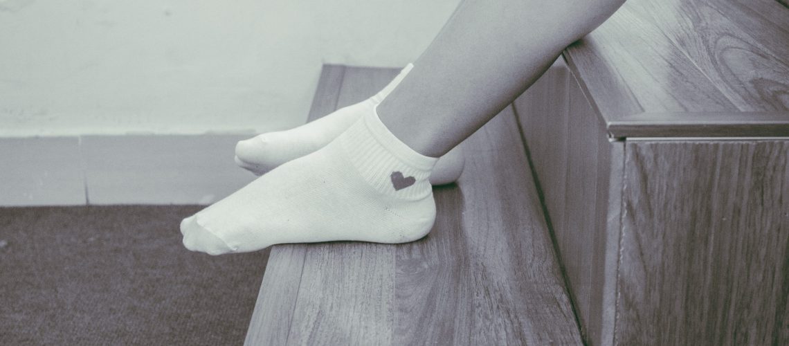 person-wearing-pair-of-foot-socks-sitting-on-staircase-1057005