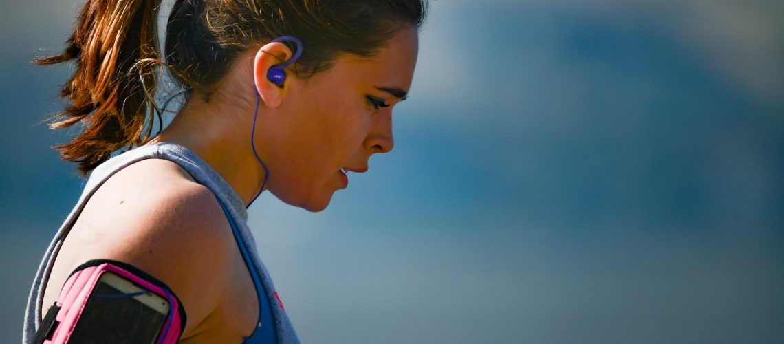 woman-wearing-smartphone-armband-and-blue-earphones-2291874